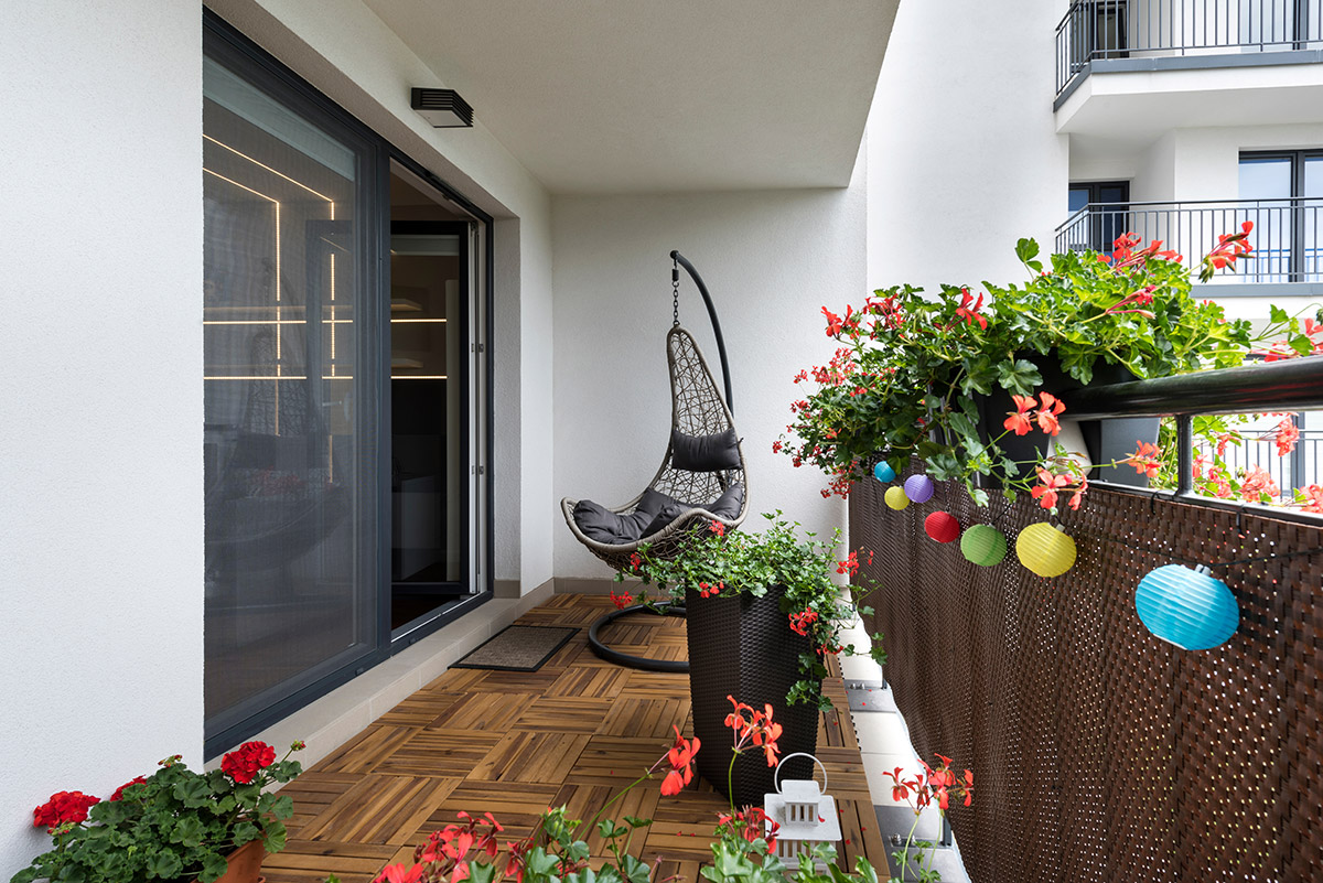 coin lecture ensoleillé avec coussins et plantes sur balcon urbain