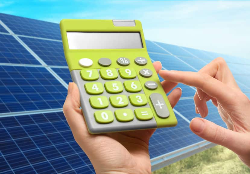 woman holding calculator and solar panels on background. reduction of expenses on electricity